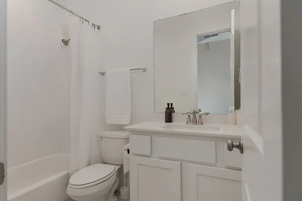 a bathroom with a sink toilet vanity and tub