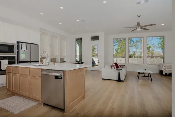 a spacious kitchen with stainless steel appliances granite countertop a stove and a sink