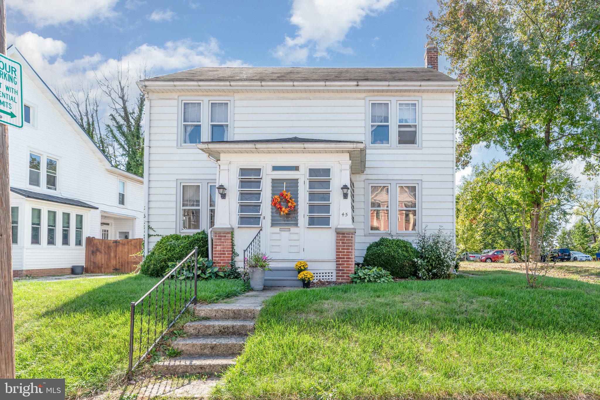 a view of a house with brick walls and a yard with plants