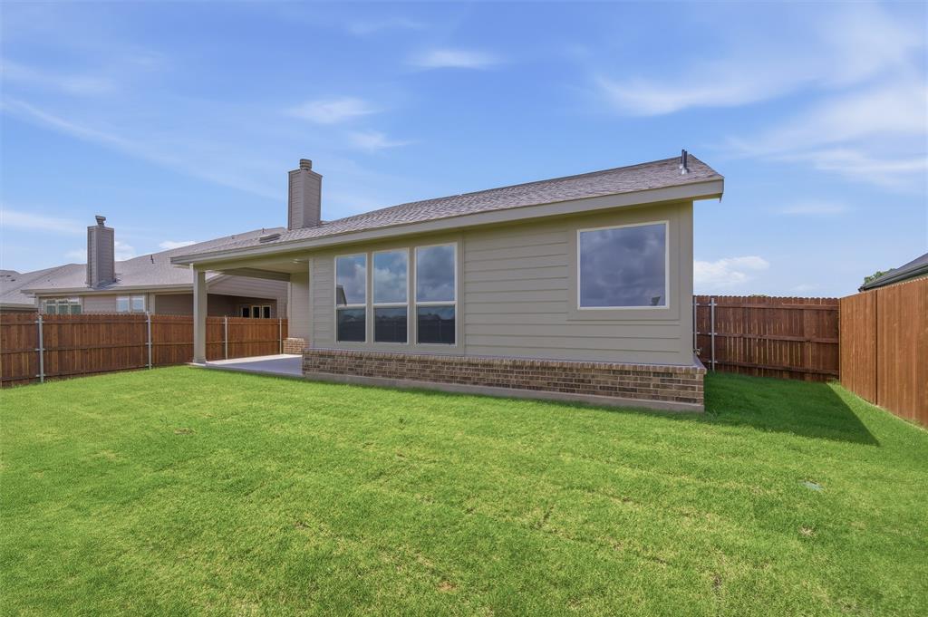 1217 Colca Drive Springtown, TX 76082 - Photo 24 of 25 Expansive backyard featuring a manicured lawn, full privacy fencing, and a concrete patio