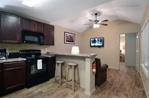 a kitchen with stainless steel appliances granite countertop a refrigerator a stove top oven a sink and dishwasher with wooden floor