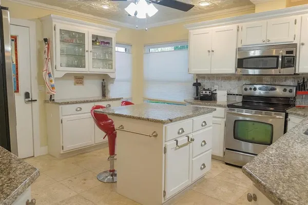 a kitchen with stainless steel appliances granite countertop a stove a sink and a refrigerator