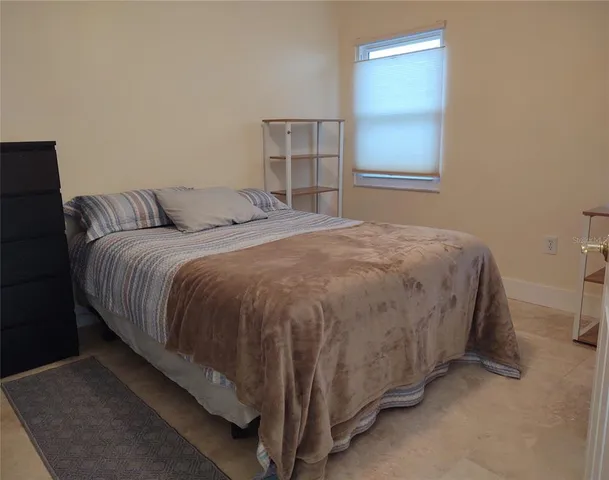a bed sitting in a bedroom next to a window