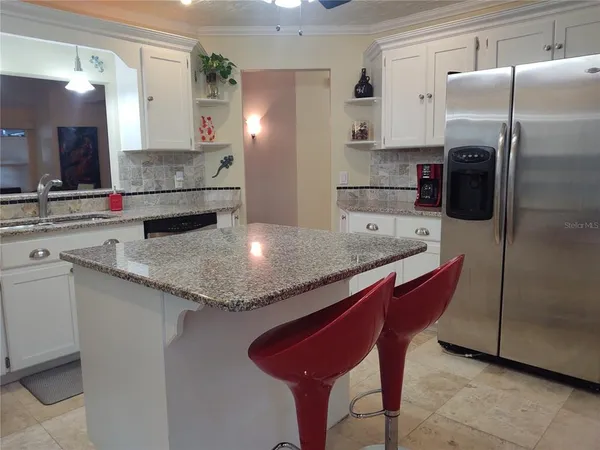 a kitchen with stainless steel appliances granite countertop a sink refrigerator and microwave