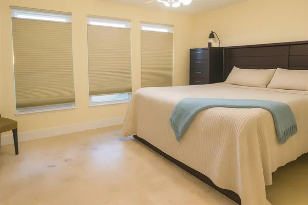 a bedroom with a bed and a ceiling fan