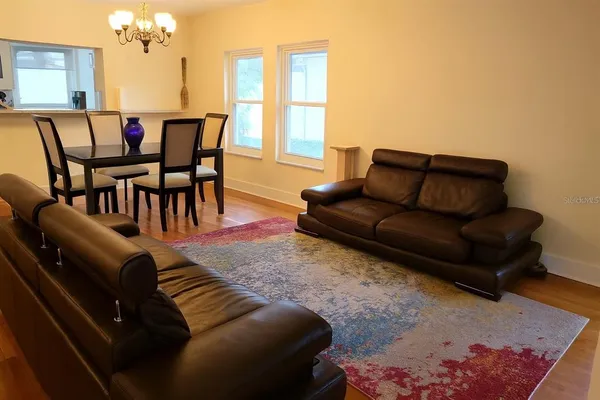 a living room with furniture and a chandelier