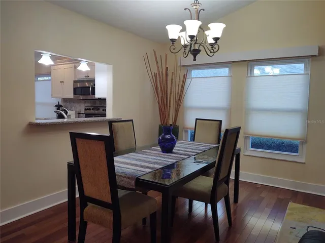 a view of a dining room with furniture a chandelier and wooden floor