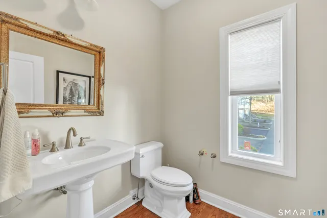 a bathroom with a toilet sink vanity and mirror