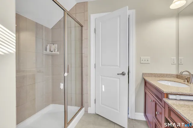 a bathroom with a granite countertop sink a mirror and a bathtub