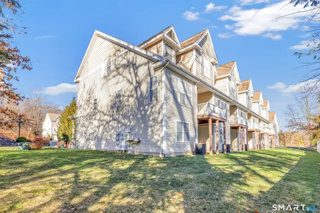 a view of a big house with a big yard and a large tree