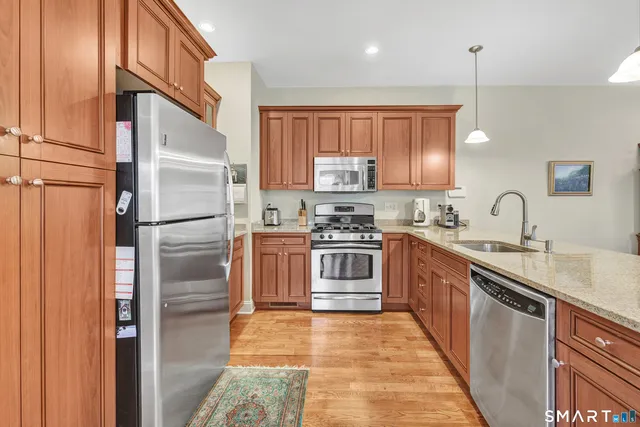 a kitchen with stainless steel appliances granite countertop a refrigerator sink and cabinets