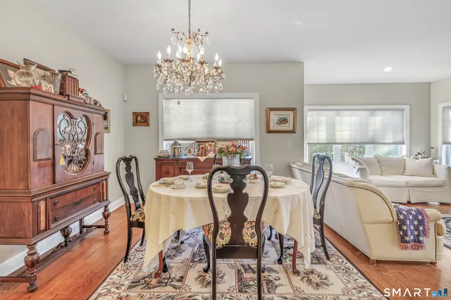 a view of a dining room with furniture a chandelier and wooden floor