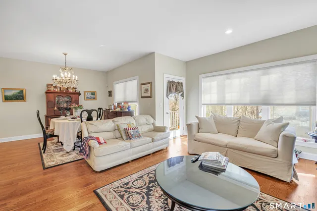 a living room with furniture or chandelier and a wooden floor