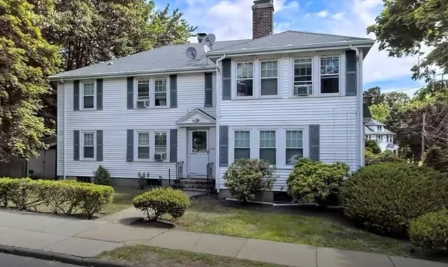 a front view of a house with a garden