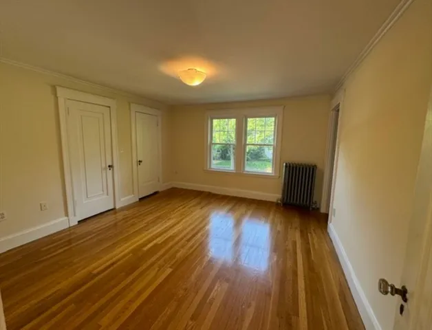 a view of a hallway with wooden floor and closet