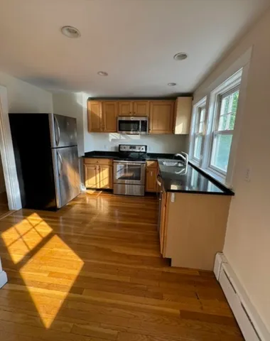 a kitchen with stainless steel appliances granite countertop a refrigerator and a stove top oven