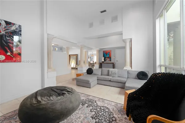 a view of an empty room with a fireplace and a chandelier fan