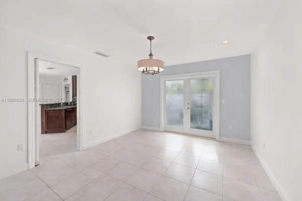 a kitchen with stainless steel appliances kitchen island granite countertop a table chairs and a refrigerator