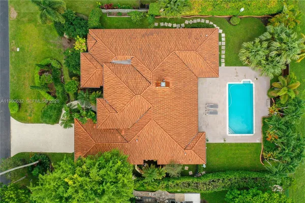 an aerial view of a tennis ground with a swimming pool