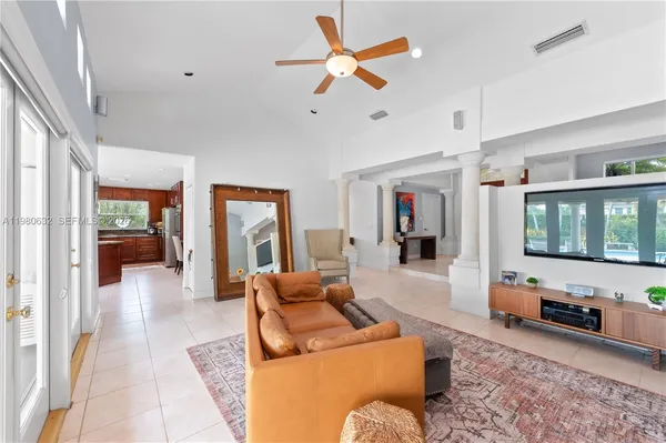 an empty room with wooden floor ceiling fan and windows