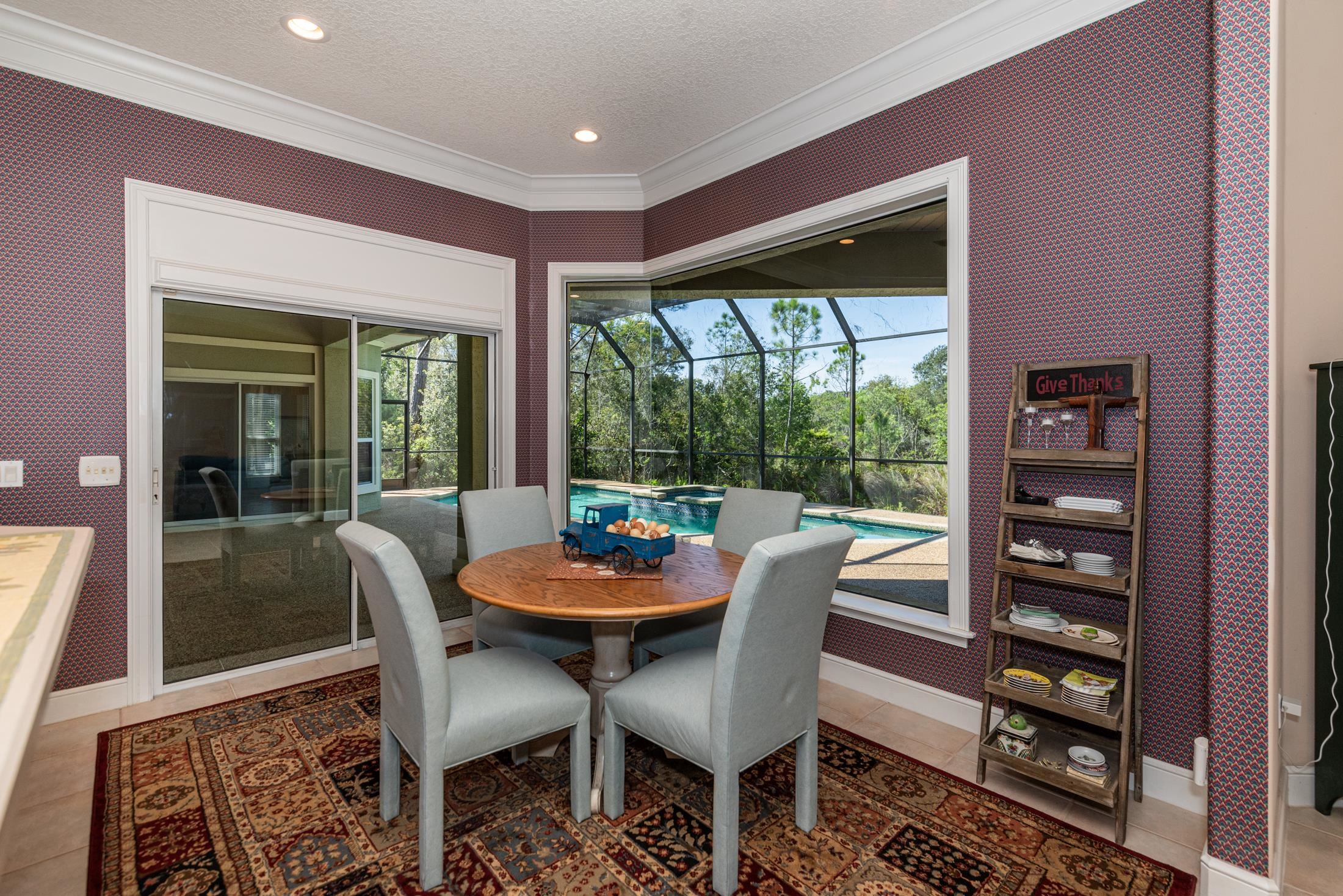 239 Marshside Drive St. Augustine, FL 32080 - Photo 21 of 57 a dining room with furniture a rug and a floor to ceiling window