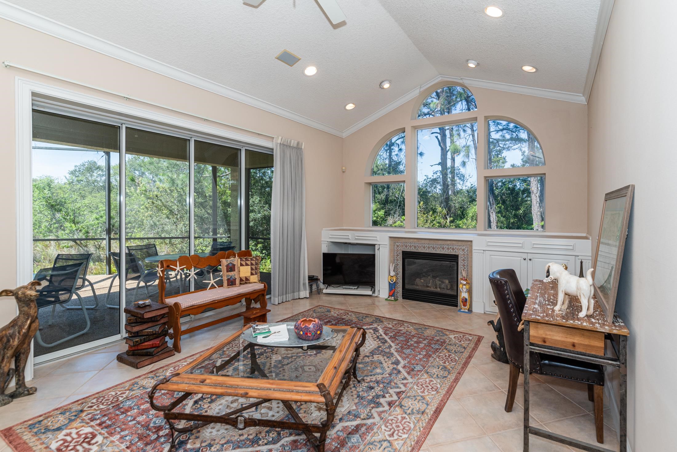 239 Marshside Drive St. Augustine, FL 32080 - Photo 26 of 57 a living room with furniture a fireplace and a floor to ceiling window