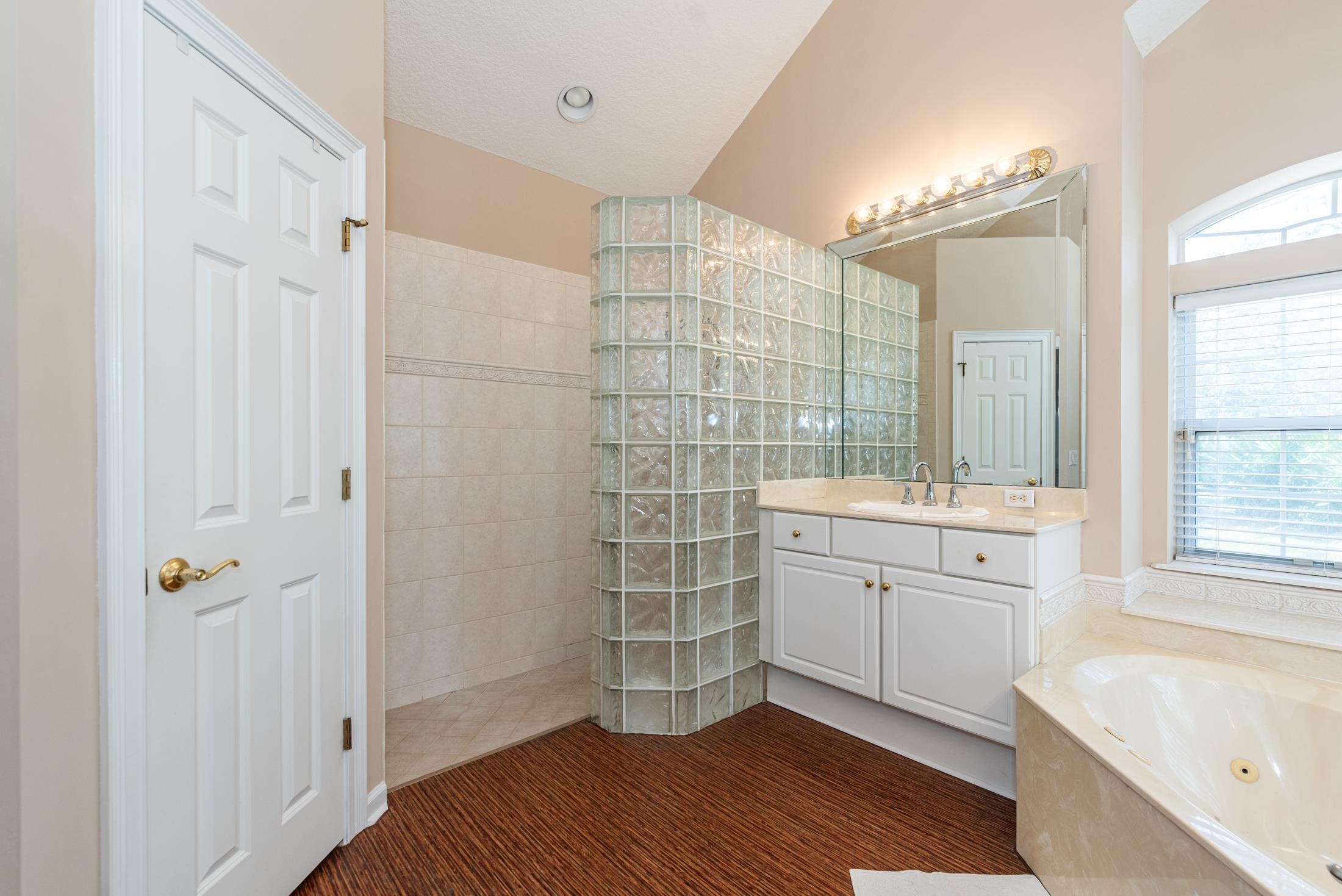 239 Marshside Drive St. Augustine, FL 32080 - Photo 47 of 57 a bathroom with a double vanity sink a mirror and a bathtub