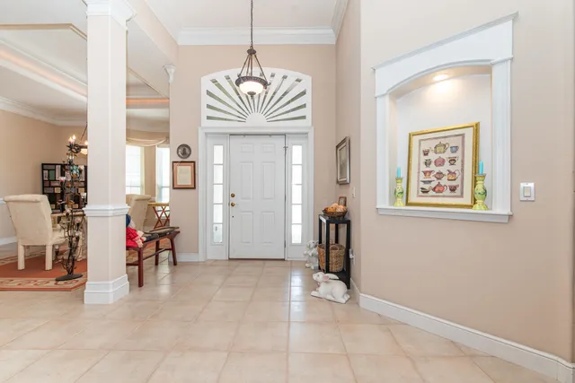 a dining room with furniture a chandelier and wooden floor