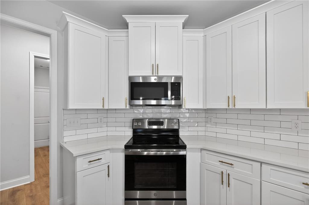 3156 Sweetbriar Drive Villa Rica, GA 30180 - Photo 21 of 45 a kitchen with stainless steel appliances granite countertop white cabinets and a stove