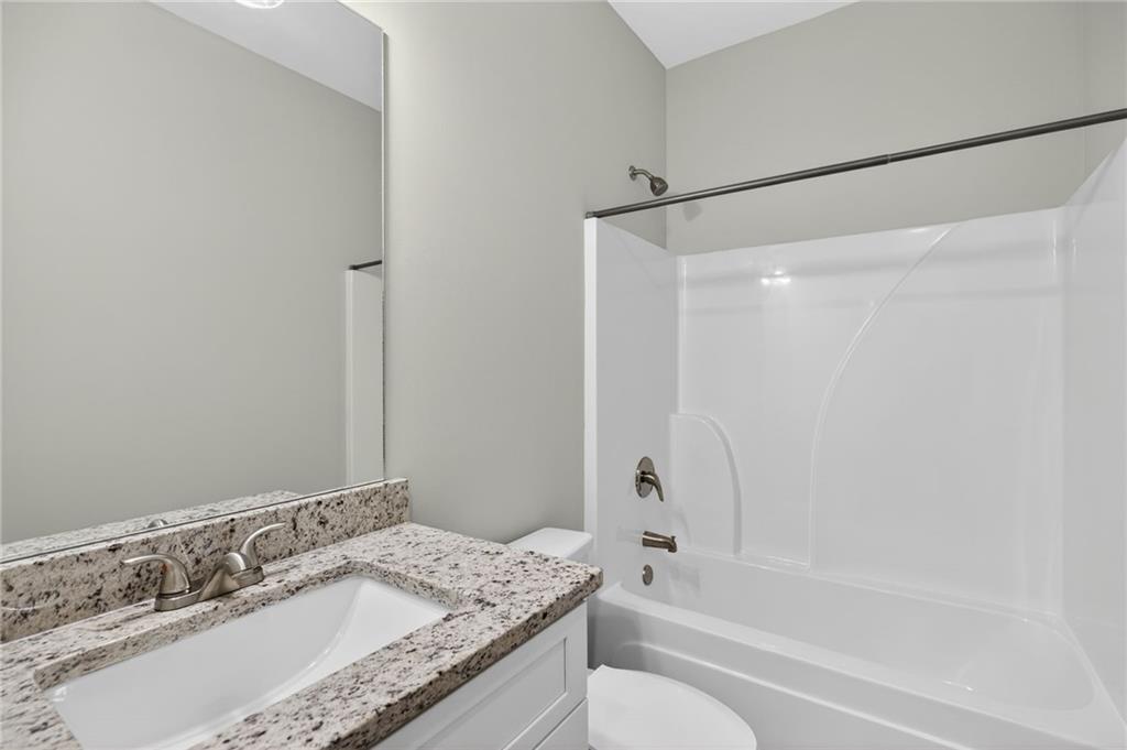 3156 Sweetbriar Drive Villa Rica, GA 30180 - Photo 30 of 45 a bathroom with a granite countertop sink mirror toilet and bathtub