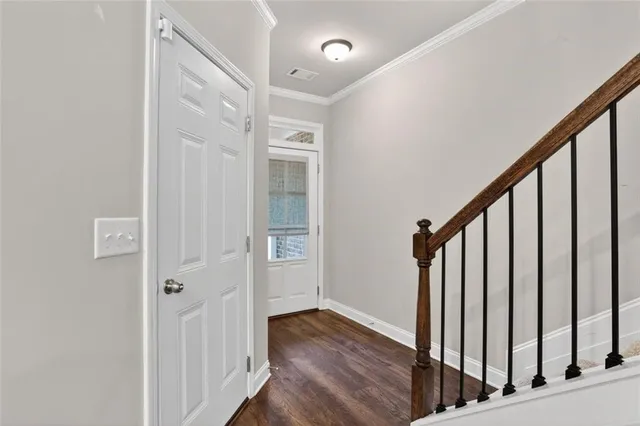 a view of a hallway with wooden floor and staircase