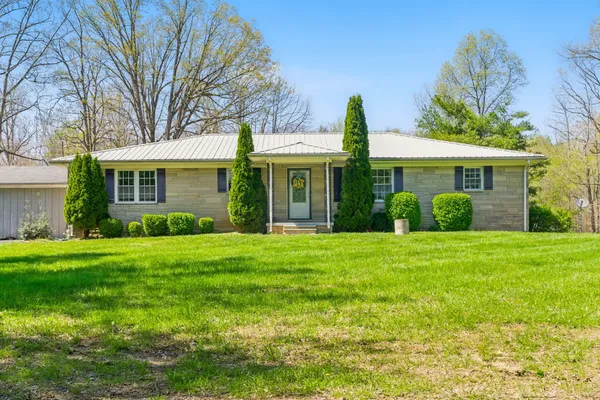 a front view of a house with a yard and potted plants