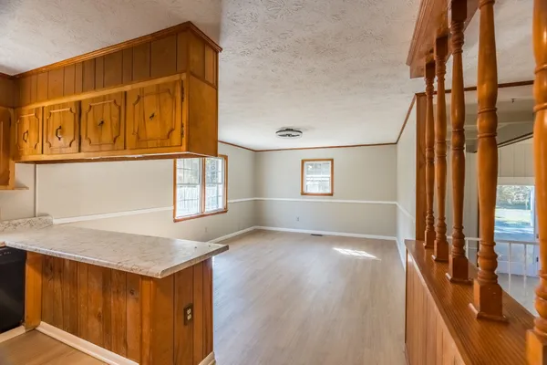 a view of an empty room with window and wooden floor
