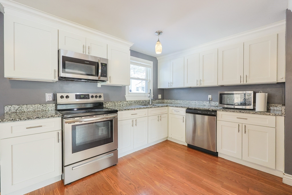 128 Salem Road Billerica, MA 01821 - Photo 11 of 42 a kitchen with stainless steel appliances granite countertop a stove a sink and a microwave