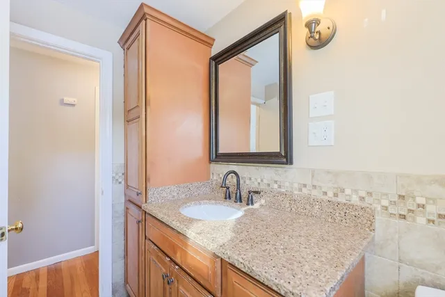 a bathroom with a granite countertop sink and a mirror