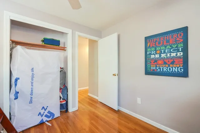 a view of hallway with wooden floor and closet