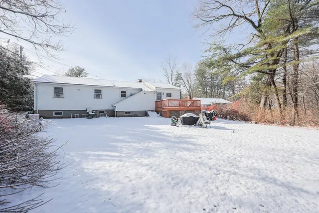 a front view of a house with a yard covered in snow