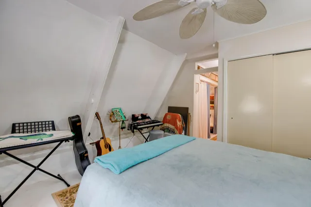 a bedroom with bed and wooden floor