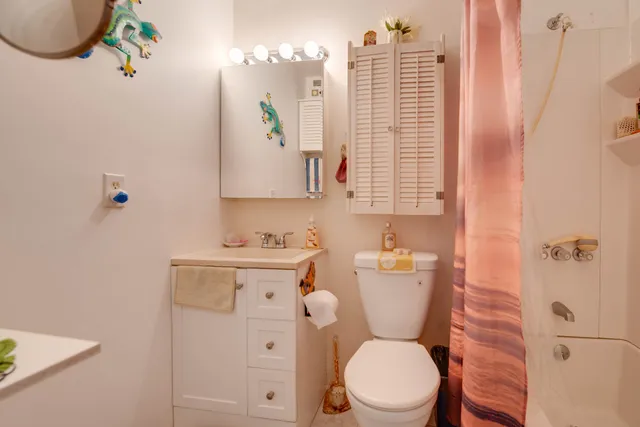 a bathroom with a toilet a sink and a window