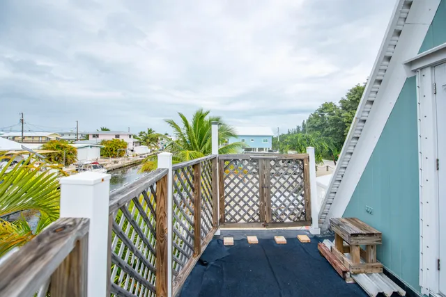 a balcony with wooden floor and city view