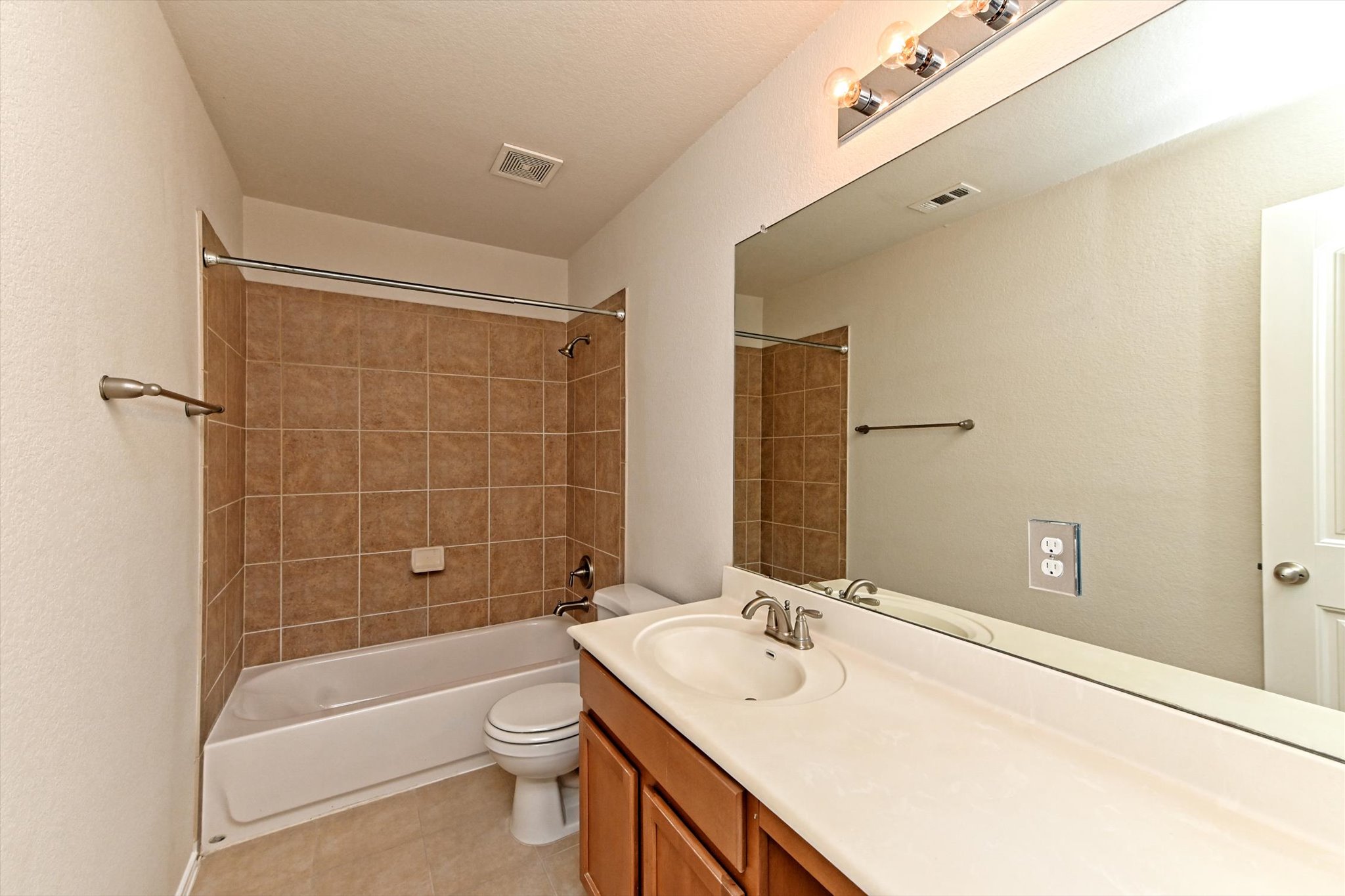 31 Stone Terrace Drive Austin, TX 78734 - Photo 24 of 29 Bathroom with vanity, shower / bathtub combination, light tile patterned floors, and a textured wall