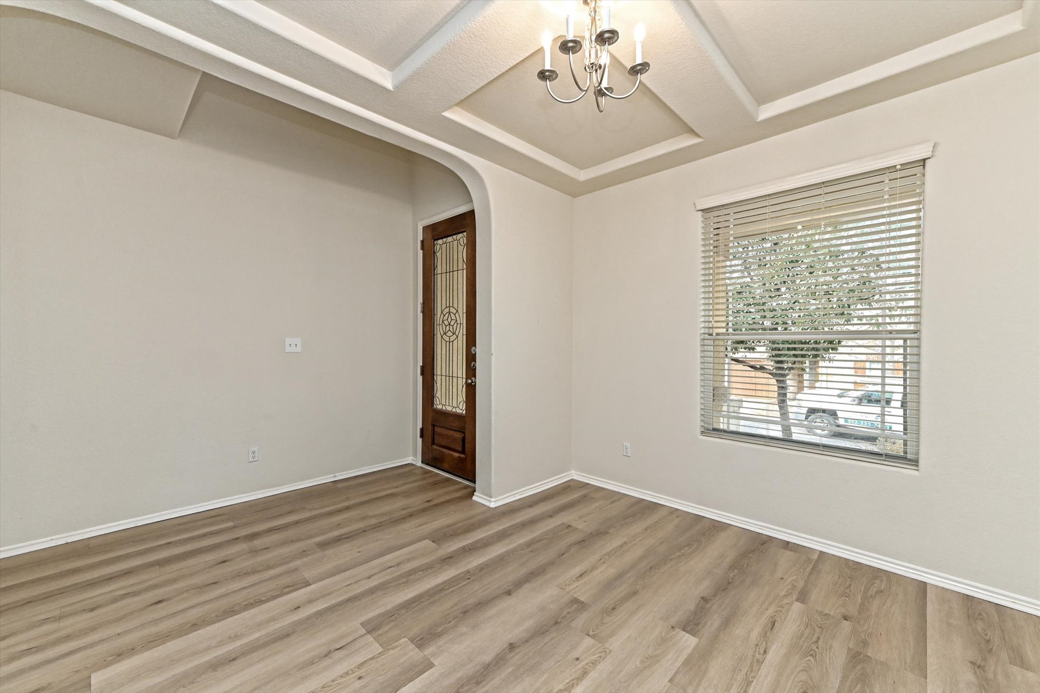 31 Stone Terrace Drive Austin, TX 78734 - Photo 3 of 29 Empty room featuring arched walkways, light wood finished floors, and a chandelier