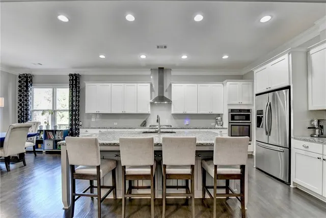 a large kitchen with stainless steel appliances granite countertop a lot of counter space and wooden floor