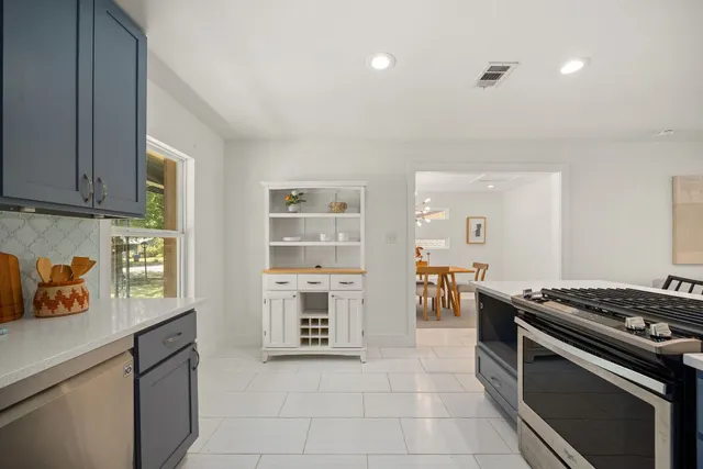 a kitchen with stainless steel appliances granite countertop a stove a sink and a refrigerator