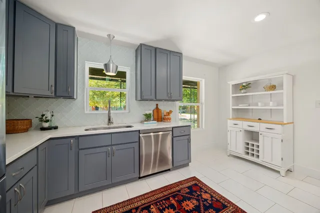 a kitchen with a sink window and cabinets
