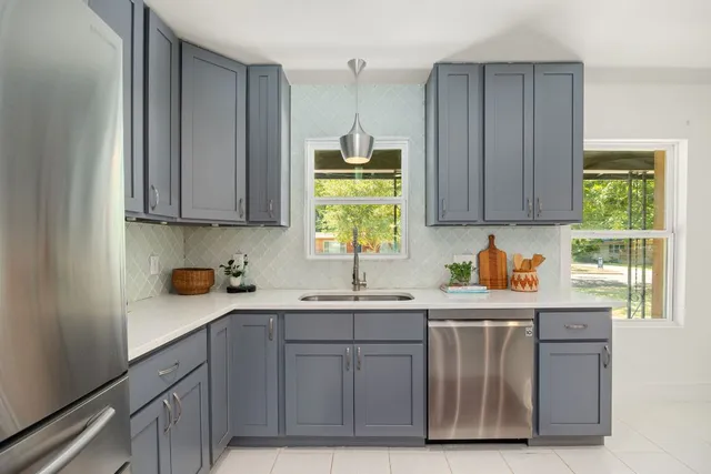 a kitchen with stainless steel appliances granite countertop a sink a stove and cabinets