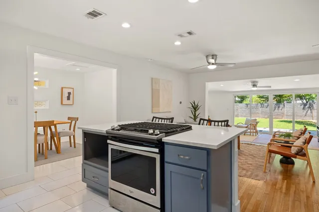 a kitchen that has a stove a table and chairs in it