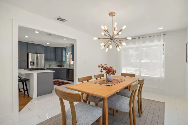 a view of a dining room with furniture and a chandelier