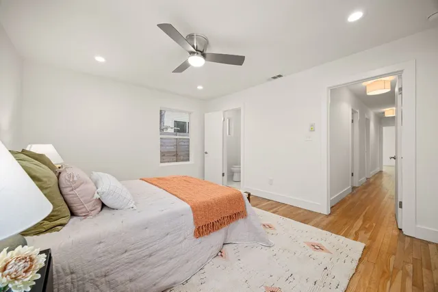 a bedroom with a large bed and a wooden floor