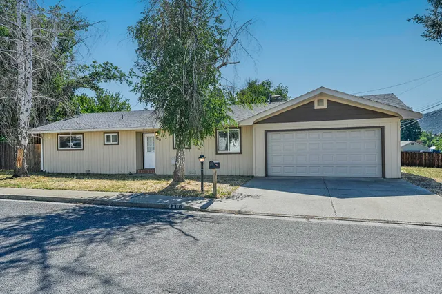 a front view of a house with a space and trees